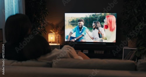 Brunette young women couple lesbian sitting in the living room watching tv resting at the weekends afterlong had week. Realtionship concept. Over the shoulder shot.
