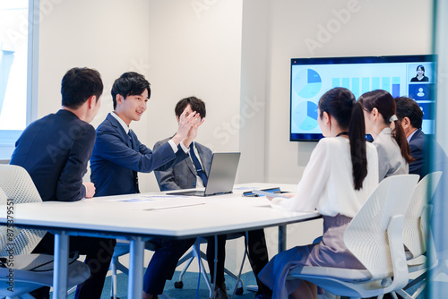 スーツを着て会議で話す若い男性