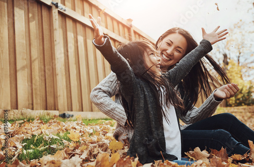 Asian, woman and girl in outdoor, park or garden with enjoying autumn, playing and fun for bonding. Female person, child and together as mother and daughter family on weekend, break or relax in Japan photo