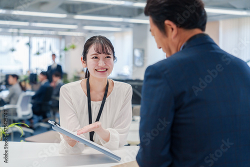 Obraz na płótnie 窓口で来客の対応をする女性スタッフ