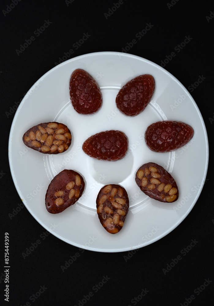 Marmalade in the form of forest cones. Marmalade with pine nuts on a white plate. Marmalade in the form of forest cones. Marmalade with pine nuts on a white plate.