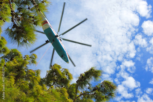 Firefighter Helicopter in the Sky Close Against the Background of Trees