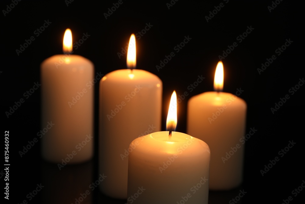 Many burning candles on black background, closeup Many burning candles on black background, closeup