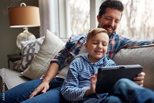Man, child and tablet on couch with internet for educational gaming, movie bonding and online tv show. Family, father and son with digital tech in home in living room for relax, streaming and happy