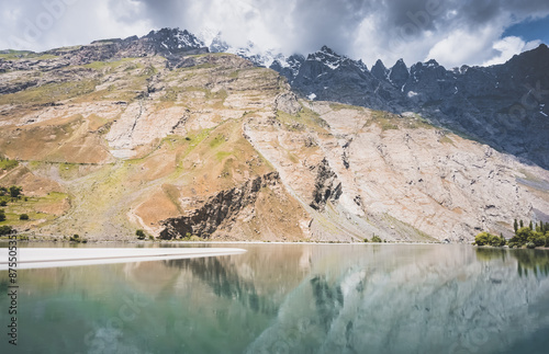 Blue mirror water of Panj river between Afghanistan and Tajikistan, river flows in a valley among rocky mountains in the Pamirs, panoramic landscape for background photo