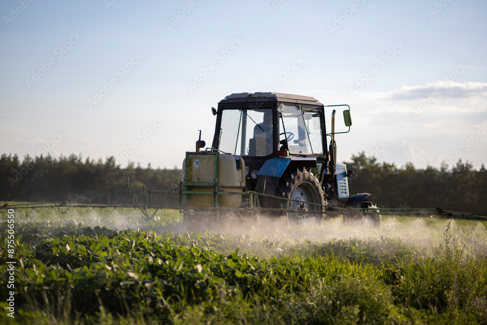 A tractor with a sprayer sprinkles soybean herbicide A tractor with a sprayer sprinkles soybean herbicide