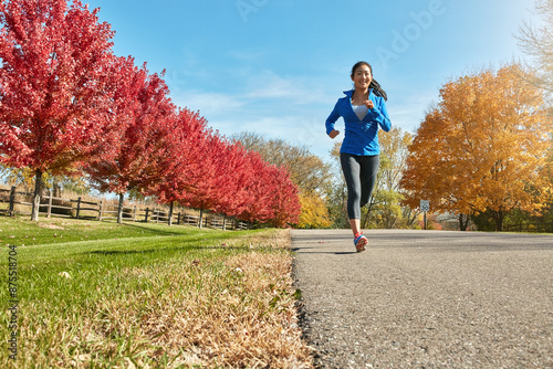 Running, asian woman and happy with fitness for cardio workout, training or outdoor exercise in countryside. Active female person, athlete or runner with smile for sprint on road in autumn or nature