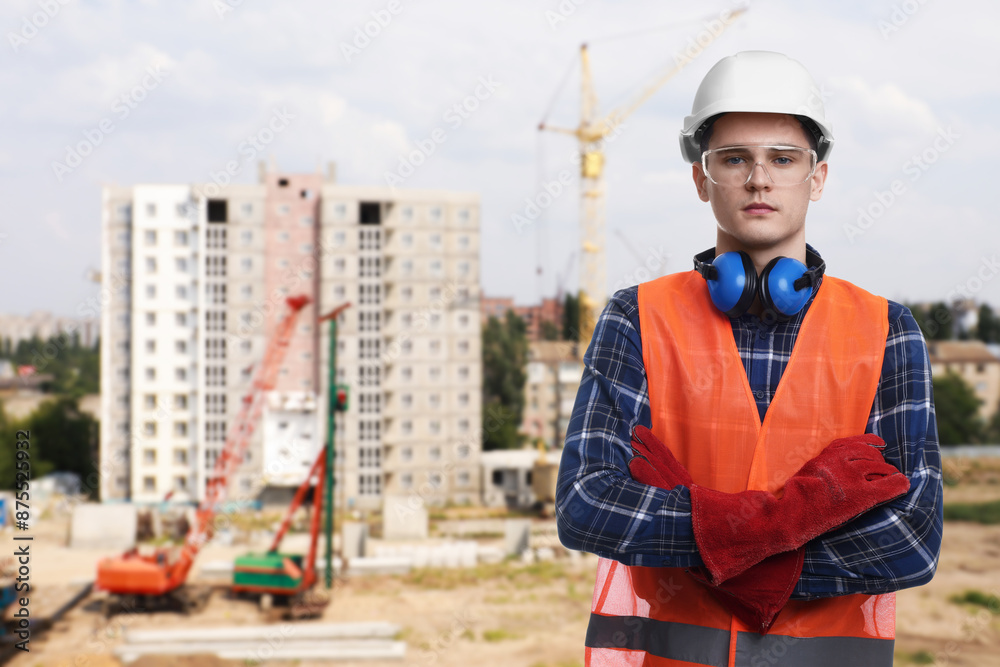 Young man wearing safety equipment at construction site. Space for text Young man wearing safety equipment at construction site. Space for text