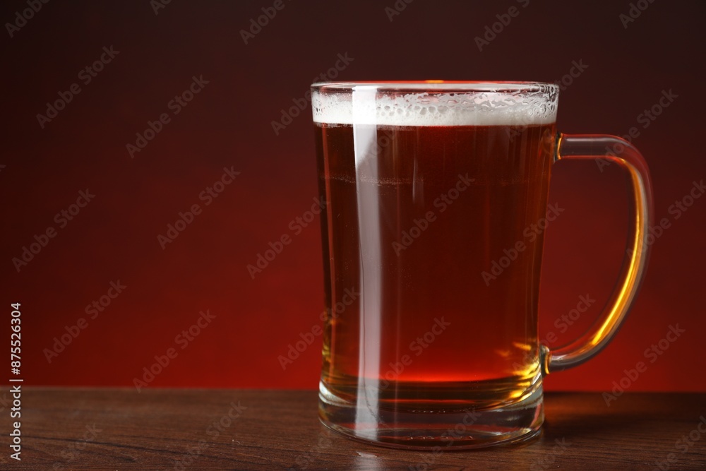 Mug with fresh beer on wooden table against color background, closeup. Space for text Mug with fresh beer on wooden table against color background, closeup. Space for text