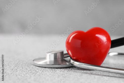 Stethoscope and red heart on grey stone table. Space for text © New Africa