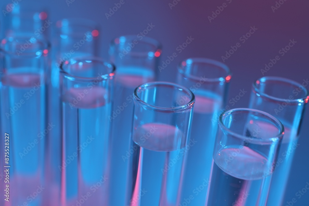 Many glass test tubes on color background, closeup Many glass test tubes on color background, closeup
