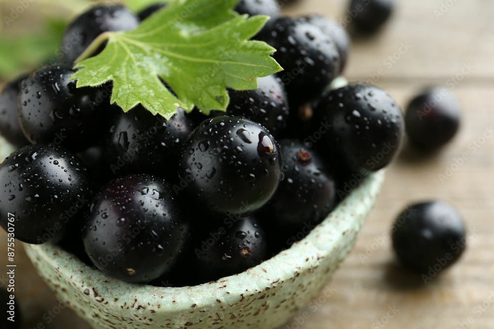 Fresh ripe black currant berries and leaf on wooden table, closeup Fresh ripe black currant berries and leaf on wooden table, closeup