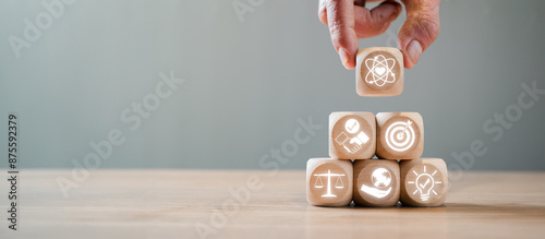 Foto Hand stacking wooden blocks with icons symbolizing core values such as innovation, balance, and growth, illustrating foundational principles in business and life