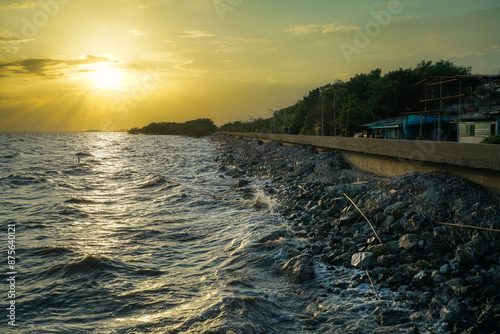 Sunset scenes over various bodies of water including a river, sea, and beach, with elements like clouds, waves, and rocks in a summer evening landscape