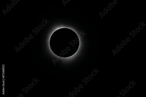 Corona surrounding the total eclipse with sun spots around the moon