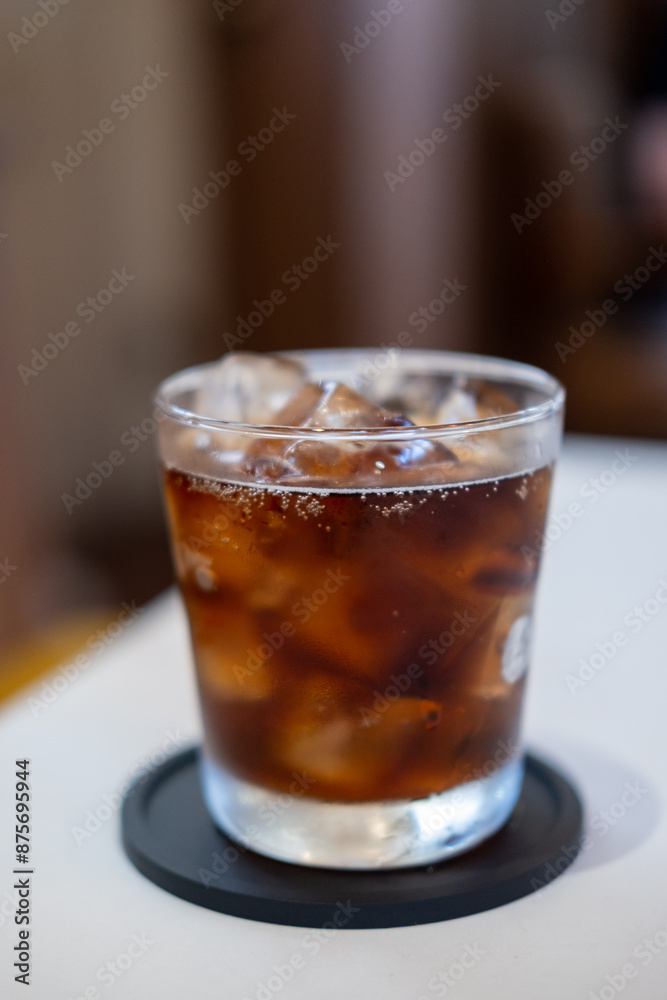 A glass of Cola on the table with blurred background A glass of Cola on the table with blurred background