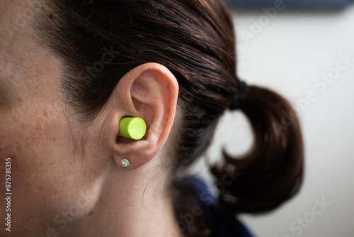 green ear plugs noise reduction sleep quiet female face ear side brown hair  photo