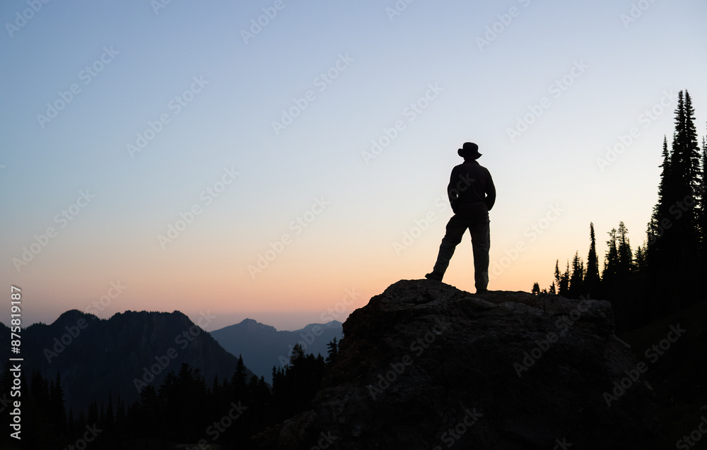 Silhouette image of a man standing on rocks at sunset. Paradise. Mount Rainier National Park. Washington State. USA.