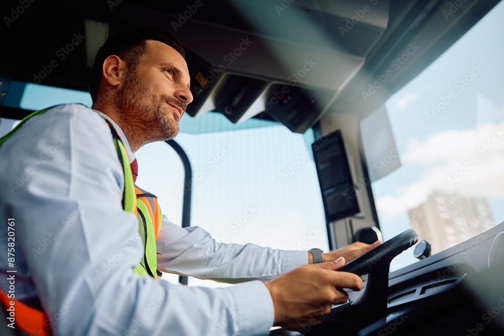 Fototapeta premium Below view of bus driver behind steering wheel.