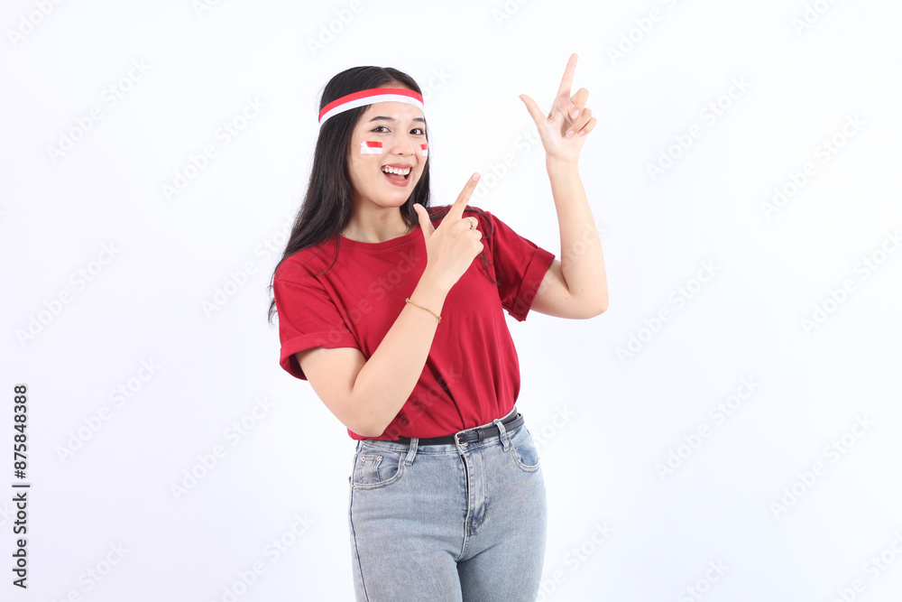 Beautiful young Asian woman pointing up to copy space and looking at camera with smile face and happy Pretty girl act like a satisfied product with celebrate Indonesian independence day on 17 August Beautiful young Asian woman pointing up to copy space and looking at camera with smile face and happy Pretty girl act like a satisfied product with celebrate Indonesian independence day on 17 August