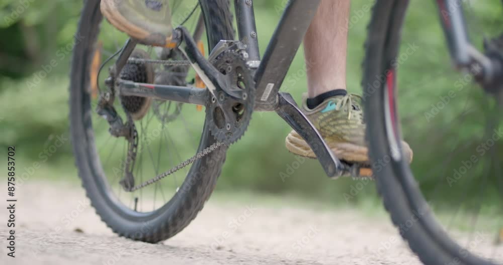 Abstract mountainbiker riding by. Man riding a mountainbike on a dusty dirth road path. Closeup pedal shoe and gear shift. Recorded at 120 fps on cinema camera. Abstract mountainbiker riding by. Man riding a mountainbike on a dusty dirth road path. Closeup pedal shoe and gear shift. Recorded at 120 fps on cinema camera.