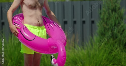 A man in an inflatable bird-shaped float with the birds neck rising upward, symbolizing an erection. photo