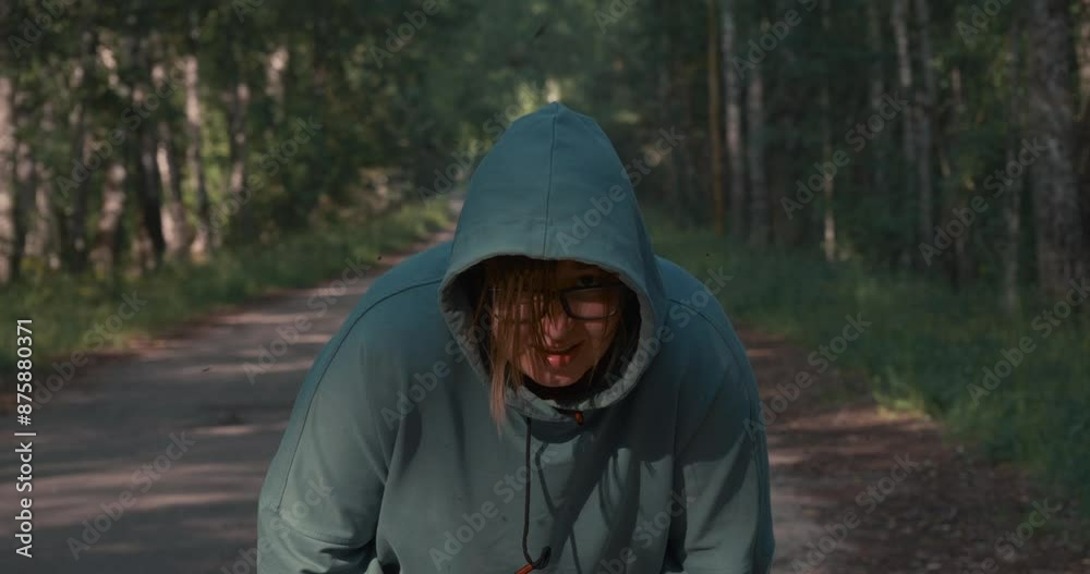Looking at the camera, a woman breathes heavily after a long run. A plump woman rests her hands on her legs and breathes heavily after a long run. An overweight woman plays sports. Looking at the camera, a woman breathes heavily after a long run. A plump woman rests her hands on her legs and breathes heavily after a long run. An overweight woman plays sports.