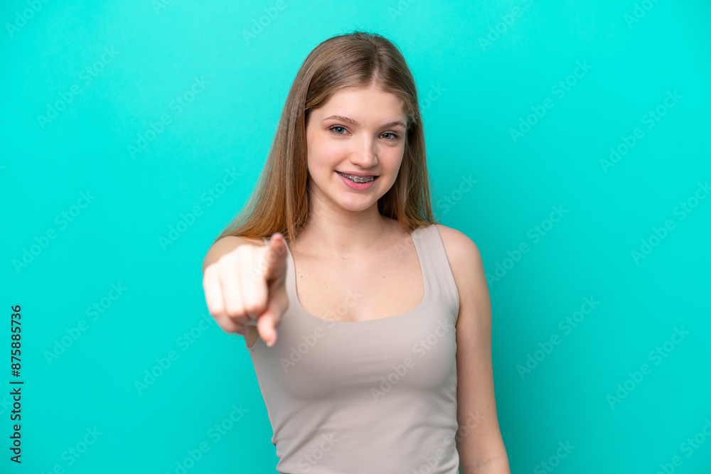 Teenager Russian girl isolated on blue background pointing front with happy expression Teenager Russian girl isolated on blue background pointing front with happy expression