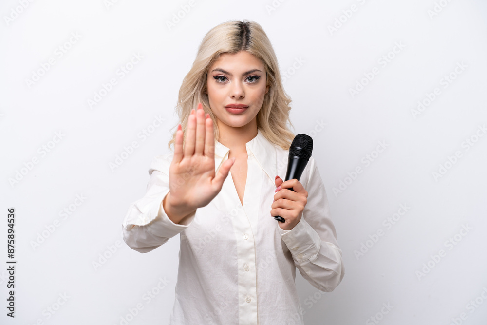 Young singer woman picking up a microphone isolated on white background making stop gesture Young singer woman picking up a microphone isolated on white background making stop gesture