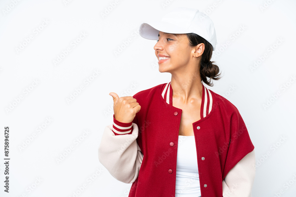 Young hispanic woman wearing a baseball uniform isolated on white background pointing to the side to present a product Young hispanic woman wearing a baseball uniform isolated on white background pointing to the side to present a product