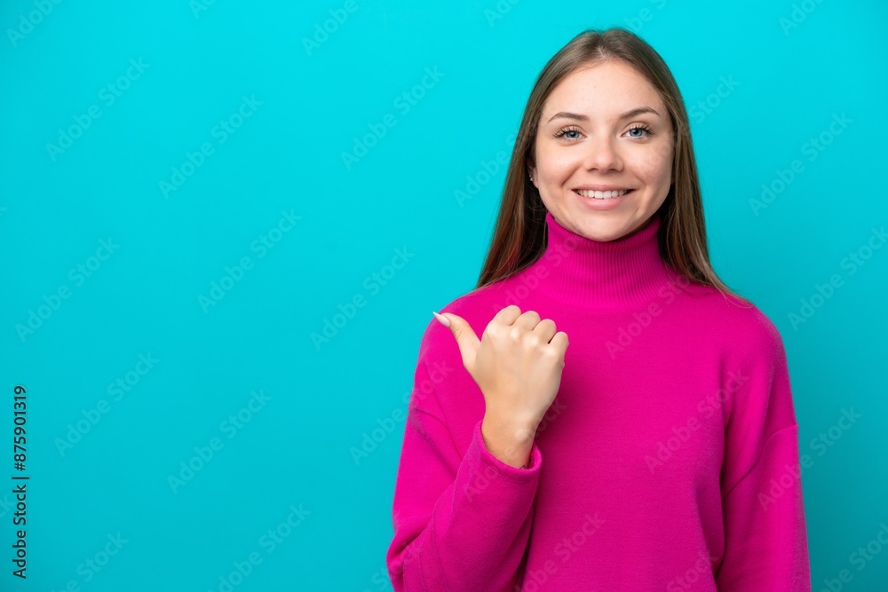 Young Lithuanian woman isolated on blue background pointing to the side to present a product Young Lithuanian woman isolated on blue background pointing to the side to present a product