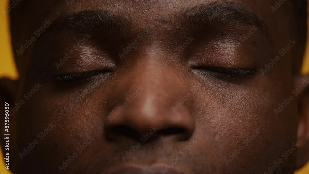Close-up Man Face with Eyes Closed Against Yellow Background Close-up Man Face with Eyes Closed Against Yellow Background