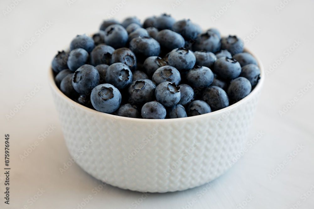 Organic Blueberries in a Bowl on a gray background, side view. Organic Blueberries in a Bowl on a gray background, side view.