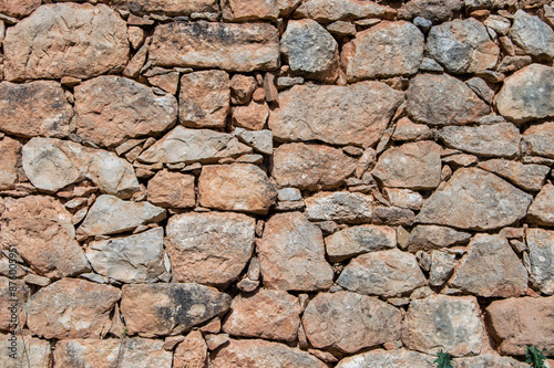 old wall with rustic reddish stones 