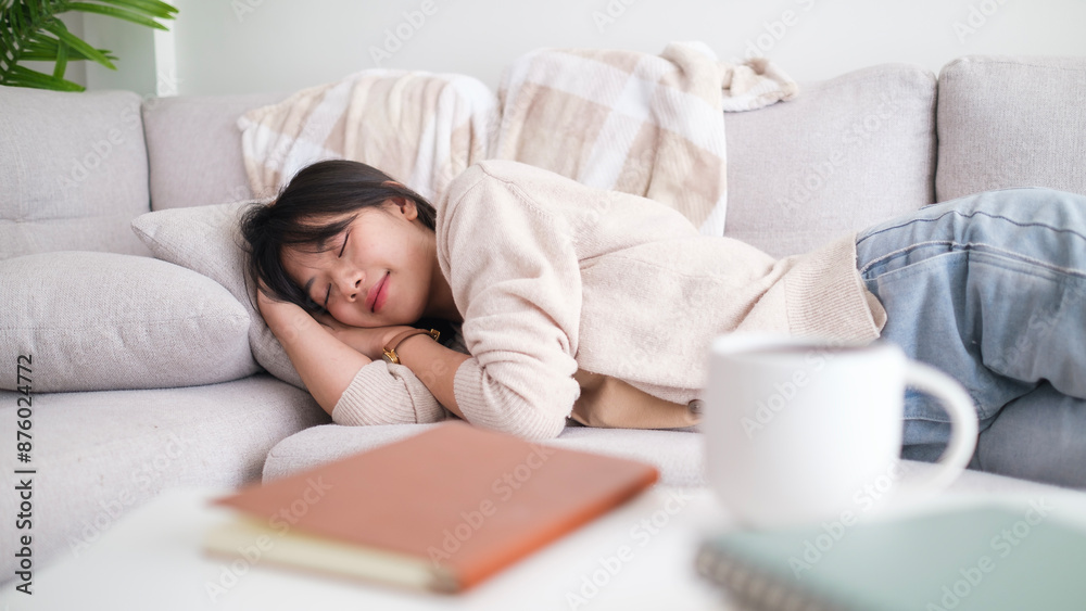 Serene young Asian woman sleeping on comfortable sofa in living room, relaxation during weekend at home. Serene young Asian woman sleeping on comfortable sofa in living room, relaxation during weekend at home.