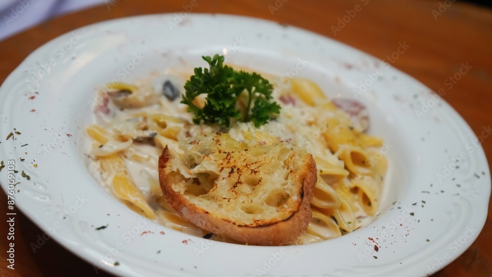 Creamy pasta with mushrooms, bacon, and a side of garlic bread. Creamy pasta with mushrooms, bacon, and a side of garlic bread.