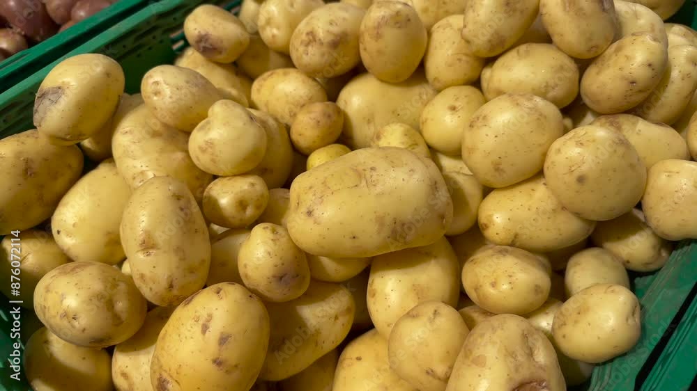 Fresh potatoes in a green plastic basket at a vegetable stand. Fresh potatoes in a green plastic basket at a vegetable stand.