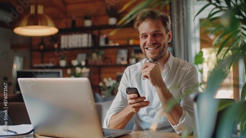 Man sitting at desk taking break in work with electronic documents on laptop to make answer telephone call. Smiling young guy freelancer synchronize data between home computer, Generative AI