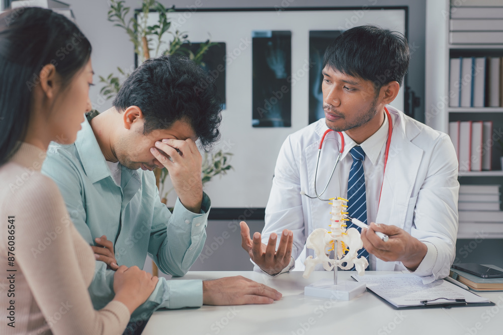 Doctor explaining spine treatment to sad patient during medical consultation Doctor explaining spine treatment to sad patient during medical consultation