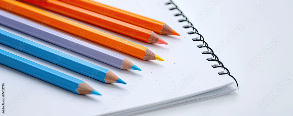 Color pencils and spiral notebook on white background. Back to school concept.