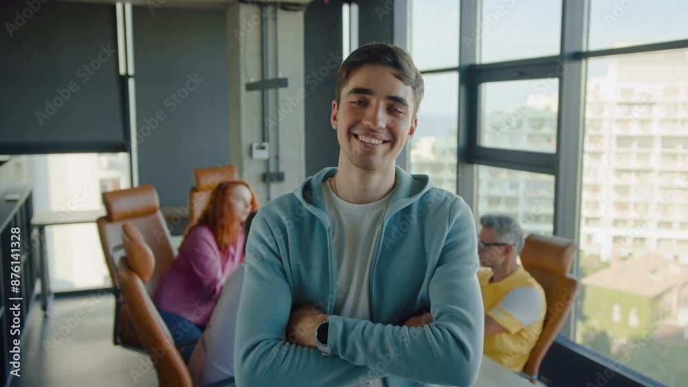 Startup owner crossing arms on waist in modern office