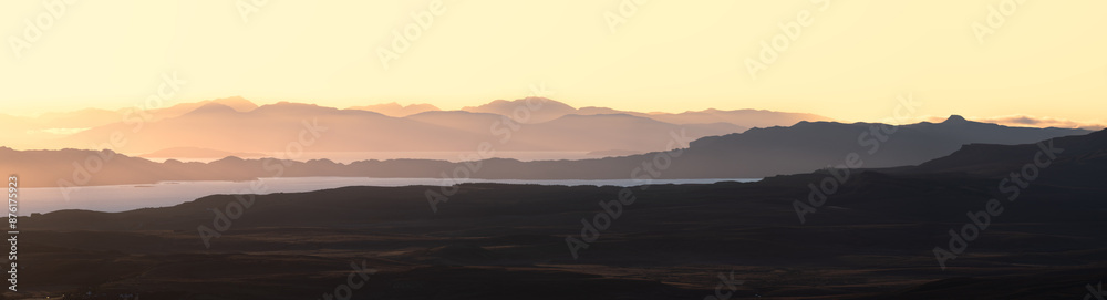 Panoramic view of hazy golden morning light breaking over mountains in The Scottish Highlands, UK. Panoramic view of hazy golden morning light breaking over mountains in The Scottish Highlands, UK.