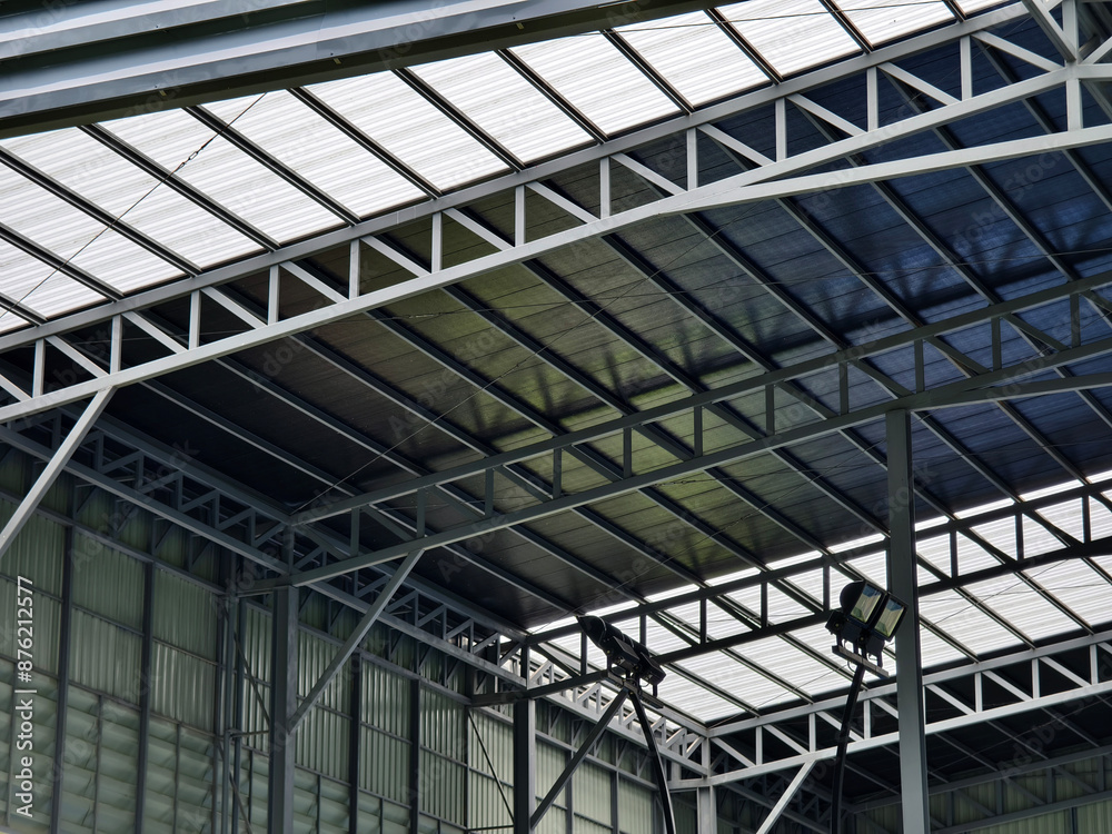 A large building with metal roof against a cloudy sky A large building with metal roof against a cloudy sky