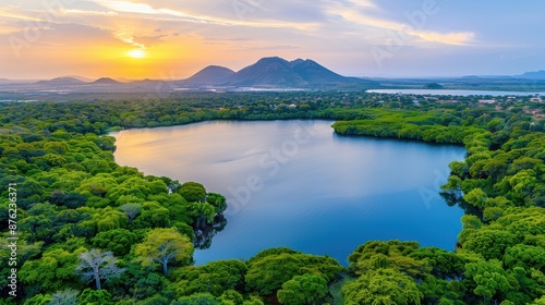 Aerial view of Gaborone Dam, serene waters reflecting the sunset, surrounded by lush greenery and urban development