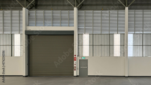 Elevation of interior factory showing steel roller shutter door, steel fire exit door, metal sheet siding, and louvers.