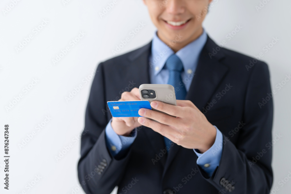 クレジットカードとスマートフォンを使うビジネス男性 クレジットカードとスマートフォンを使うビジネス男性
