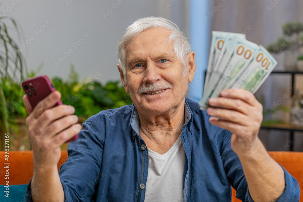 Planning family budget. Smiling senior man counting money cash use smartphone calculate domestic bills at home. Mature elderly grandfather satisfied of income, saves money for planned vacation gifts Planning family budget. Smiling senior man counting money cash use smartphone calculate domestic bills at home. Mature elderly grandfather satisfied of income, saves money for planned vacation gifts