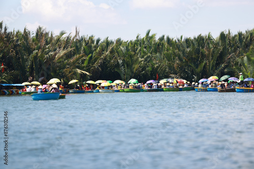 Tourists are joining the Coconut Forest Basket Boat Ride in Hoi An, vietnam. bsaket boat also called vietnamese coracle, is one of local small rounded boat for transport and fishing photo