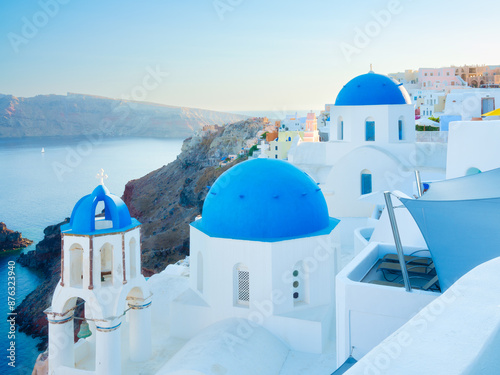Fototapeta Naklejka Na Ścianę i Meble -  Santorini, Greece. Traditional houses in Santorini. Small narrow streets and rooftops of houses, churches and hotels. Oia village, Santorini Island, Greece. Travel and vacation photography.