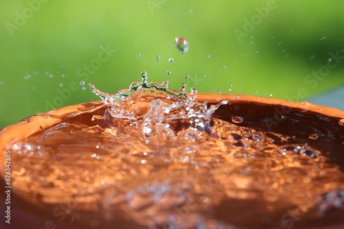 rain is falling in a small barrel full of water in the garden
